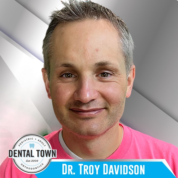 Dr. Troy Davidson gray hair soft smile pink shirt